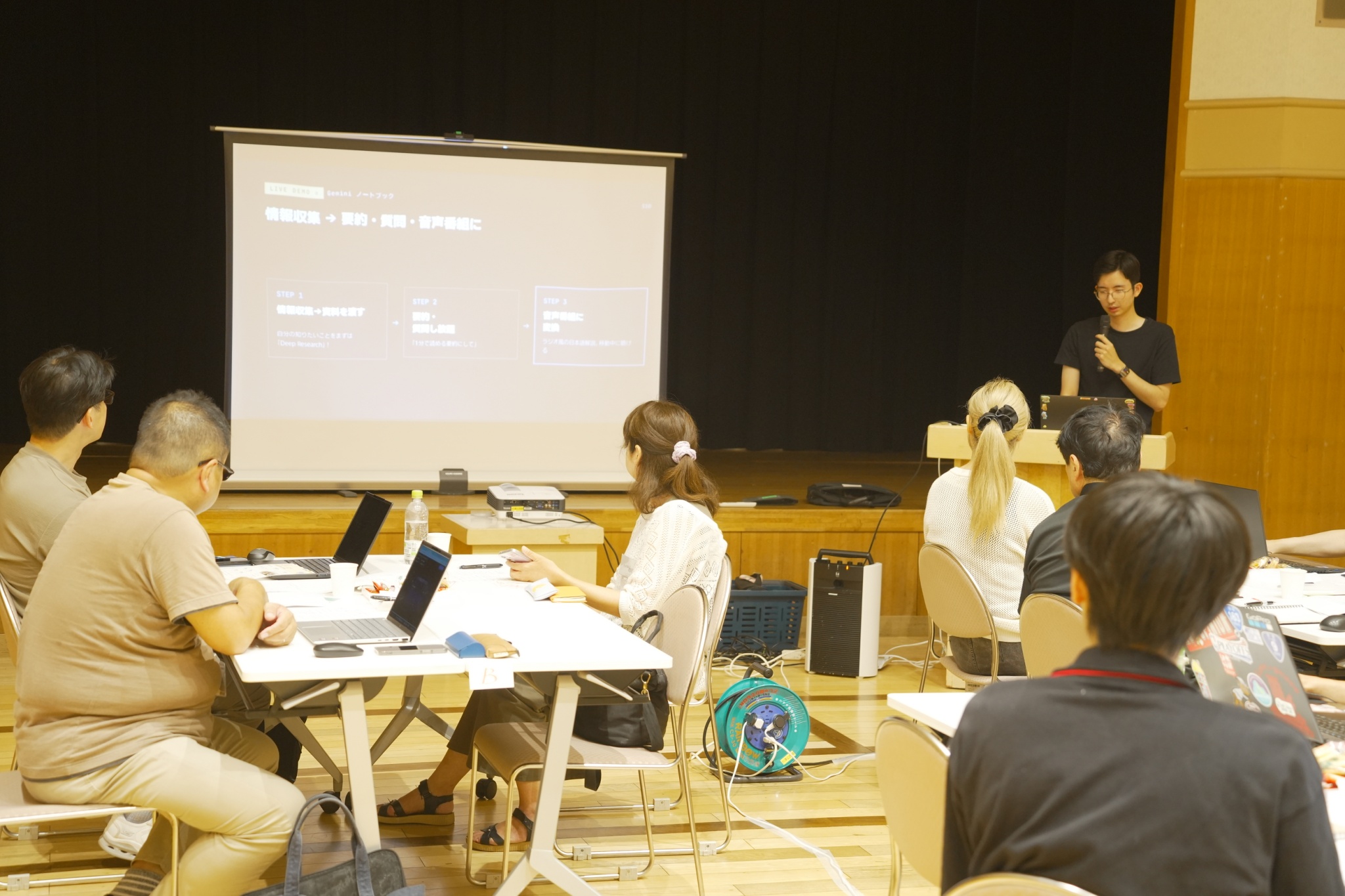 第1回松江AIアイディア工房で、講師の説明を聞きながらAIを試す参加者の様子